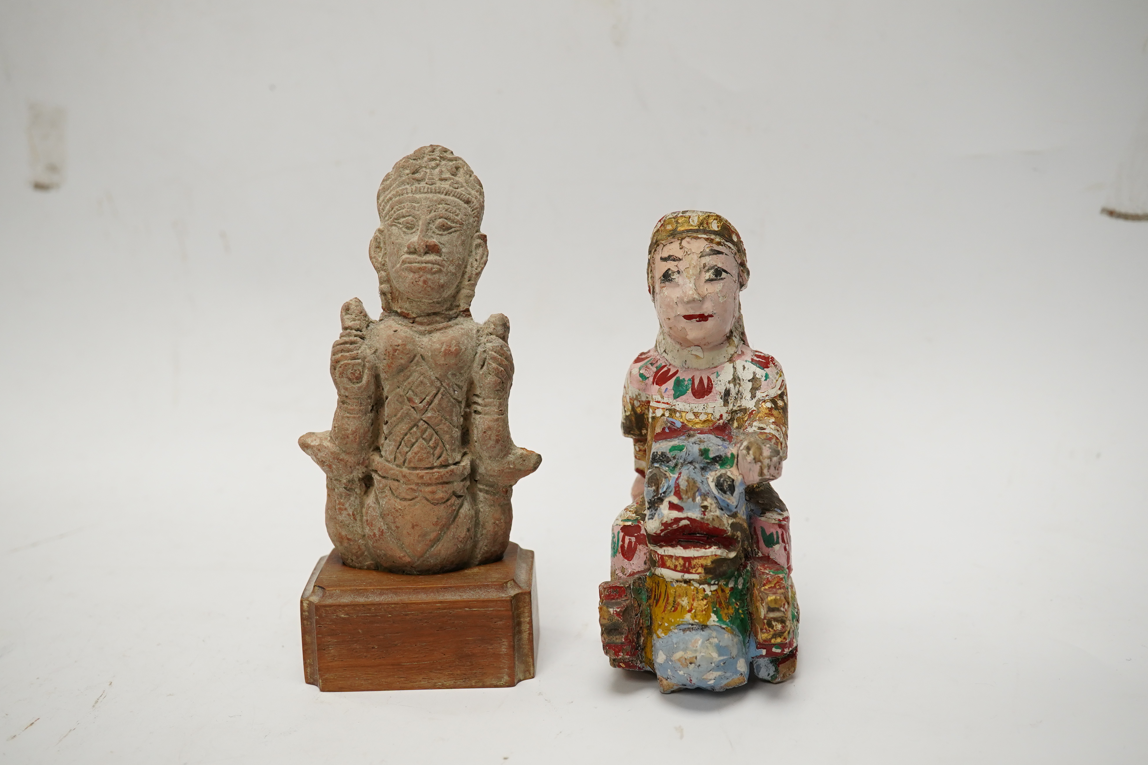 A Burmese lacquered wood figure, 19th century and an Indian terracotta figure of a deity, largest 13cm high overall. Condition - fair